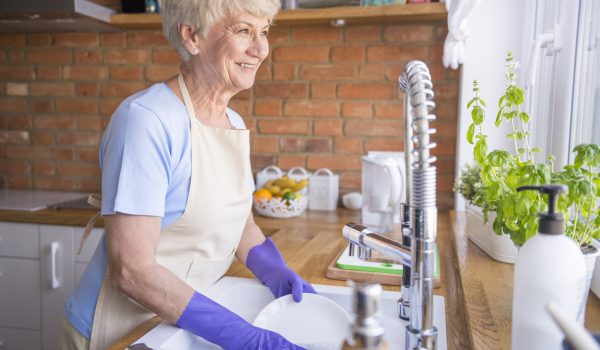 Woman washing dishes in front of the window